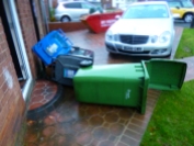 Wind blows bins over almost damaging car